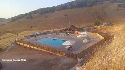 an overhead view of a swimming pool with umbrellas at Gîte Forest Tagroumte in Azrou