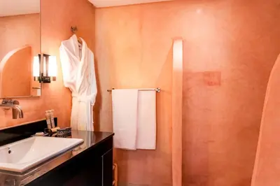 a bathroom with a sink and a mirror and a shower at Riad Al Ansari in Fès