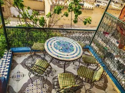 a patio with a table and chairs on a balcony at Dar Rihanne in Fès
