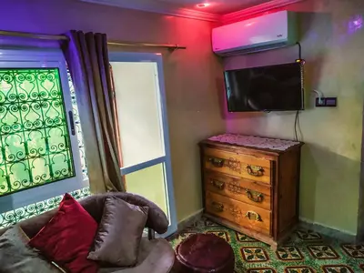 a living room with a tv and a dresser at Dar Rihanne in Fès
