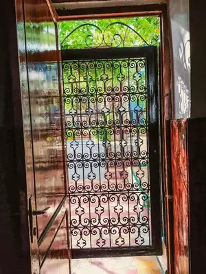 an open door with an iron gate with a window at Dar Rihanne in Fès