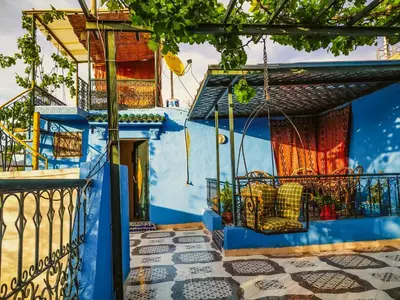 a blue house with a chair on a balcony at Dar Rihanne in Fès