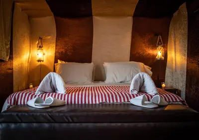 a bedroom with a bed with slippers on it at Mhamid Luxury Camp Experience in Mhamid