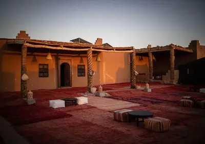a building with a courtyard with tables in front of it at Mhamid Luxury Camp Experience in Mhamid