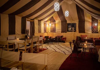 a dining room with tables and chairs in a tent at Mhamid Luxury Camp Experience in Mhamid