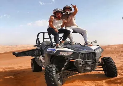 two people sitting on top of an atv in the desert at Mhamid Luxury Camp Experience in Mhamid