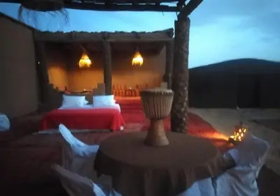 a room with two beds and a table with lights at Mhamid Luxury Camp Experience in Mhamid