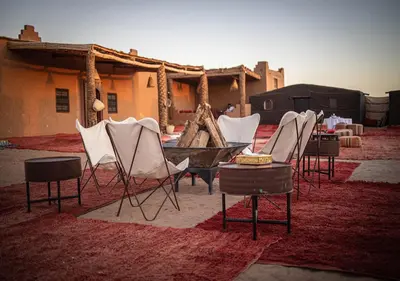 a group of chairs and tables in a room at Mhamid Luxury Camp Experience in Mhamid