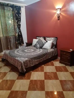 a bedroom with a bed in a room with red walls at Villa Fatima in Meknès