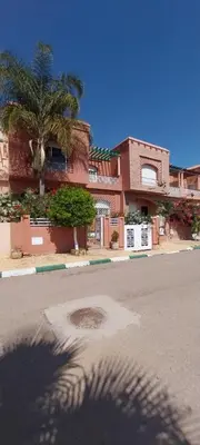 a building with a palm tree in front of a street at Villa Fatima in Meknès