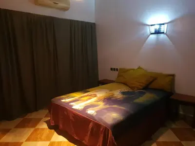 a bedroom with a bed and a light on the wall at Villa Fatima in Meknès