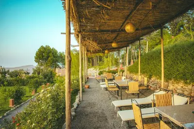 a restaurant with tables and chairs under a roof at Diar illi in Touama