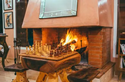 a chess board in front of a brick fireplace at Diar illi in Touama