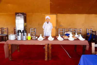 a man standing in front of a table with shoes at Luxury berber style in Merzouga