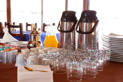 a table with glasses and bottles and plates on it at Luxury berber style in Merzouga