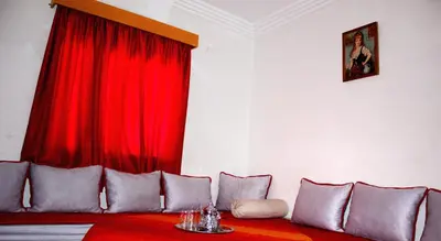 a living room with a red curtain and a couch at Appartement Afgo Ouarzazate in Ouarzazate