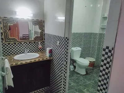a bathroom with a sink and a toilet and a mirror at Appartement Afgo Ouarzazate in Ouarzazate