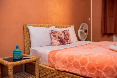 a bedroom with a bed with a pillow and a table at Appartement Afgo Ouarzazate in Ouarzazate