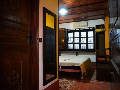 a bedroom with a bed and a window in a room at La Kasbah Elkhorbat Muxu Berbere in Asrir
