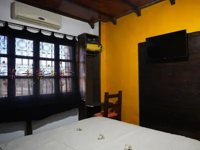 a bedroom with a bed and a tv and a window at La Kasbah Elkhorbat Muxu Berbere in Asrir