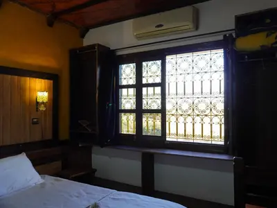 a bedroom with a window and a bed and a bed sidx sidx sidx at La Kasbah Elkhorbat Muxu Berbere in Asrir