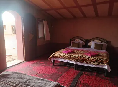 a bedroom with a bed in a room with a window at Sahara Bedouin camp in Mhamid