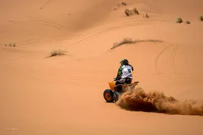 a person riding a quad bike in the desert at Sahara Bedouin camp in Mhamid