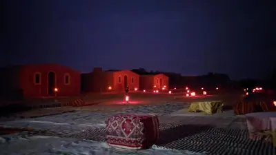 a group of buildings at night with red lights at Sahara Bedouin camp in Mhamid