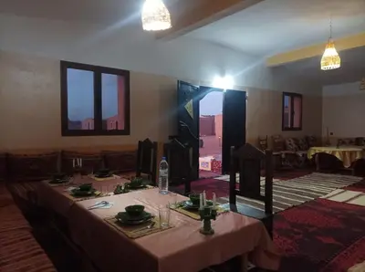 a dining room with a table with a pink table cloth at Sahara Bedouin camp in Mhamid