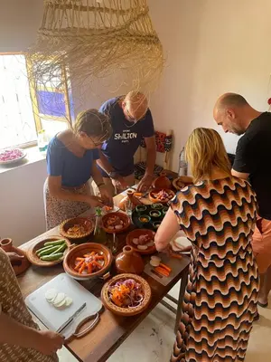 a group of people standing around a table preparing food at Maroc des Merveilles - Chez L'habitant in Kalaat MGouna