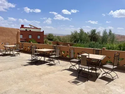 a group of tables and chairs on a patio at Maroc des Merveilles - Chez L'habitant in Kalaat MGouna
