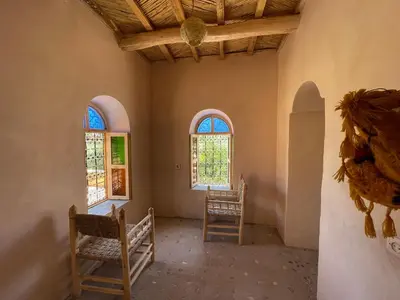 a room with two chairs and two windows at Maroc des Merveilles - Chez L'habitant in Kalaat MGouna