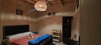 a bedroom with a bed and a chandelier at Maroc des Merveilles - Chez L'habitant in Kalaat MGouna