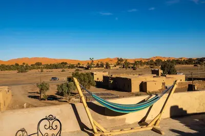 a hammock sitting on top of a building in a desert at Dar Duna in Hassilabied