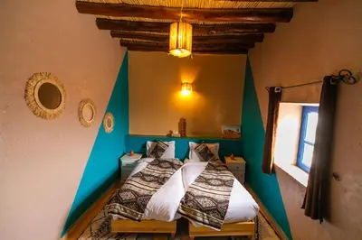 a bedroom with a bed in the corner of a room at Dar Duna in Hassilabied