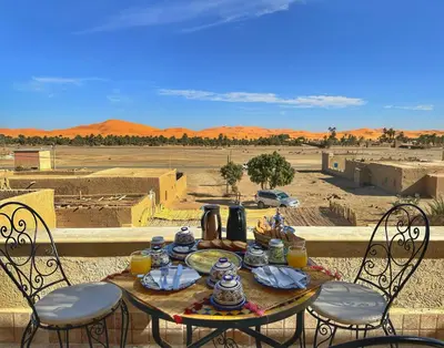 a table with food and drinks on top of a desert at Dar Duna in Hassilabied