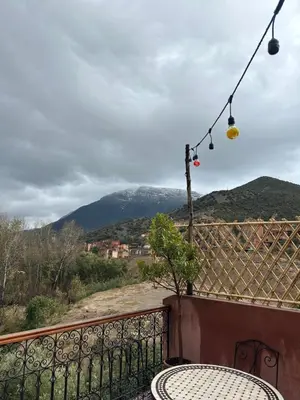 a balcony with a table and a view of a mountain at DAR TAWJA in Asguine
