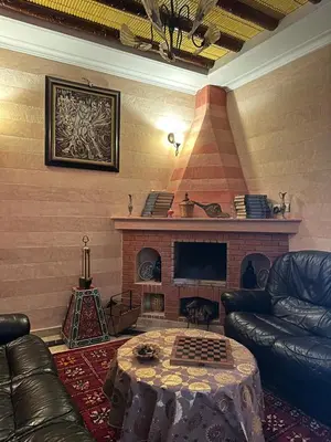 a living room with a couch and a fireplace at DAR TAWJA in Asguine