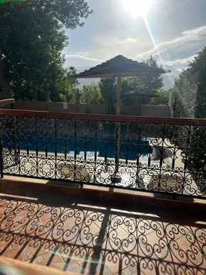 a balcony with an iron fence and an umbrella at DAR TAWJA in Asguine