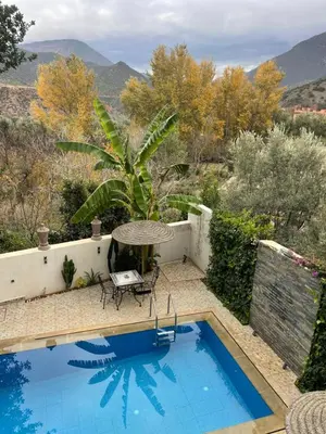 a pool with a table and a chair next to it at DAR TAWJA in Asguine