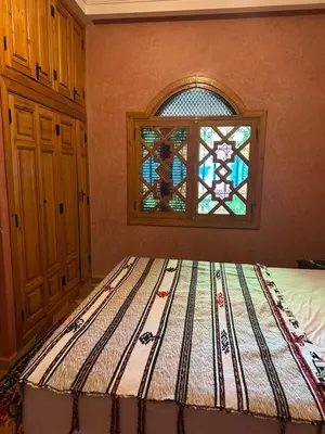 a bedroom with a bed with a stained glass window at DAR TAWJA in Asguine