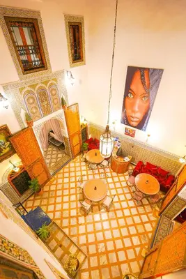 an overhead view of a room with tables and a painting at Riad Sahraui in Fès