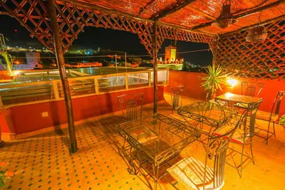 a patio with a table and chairs on a balcony at Riad Sahraui in Fès