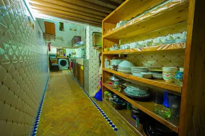 a kitchen with wooden shelves with dishes on them at Riad Sahraui in Fès