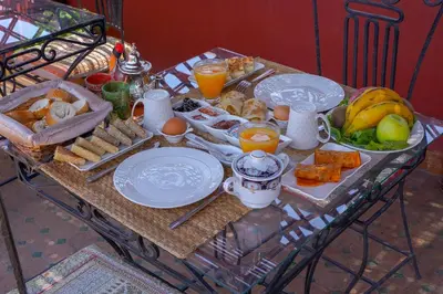 a breakfast table with breakfast foods and orange juice at Riad Sahraui in Fès