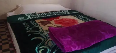 a bed with a colorful blanket and two pillows at Camp Cheri Beri in Mhamid