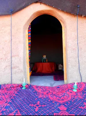 a tent with a table in the background with two candles at Camp Cheri Beri in Mhamid