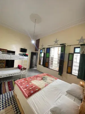 a bedroom with two bunk beds and two windows at Dar Atlantic in Fès
