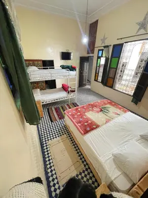 a room with two beds in the middle of a room at Dar Atlantic in Fès