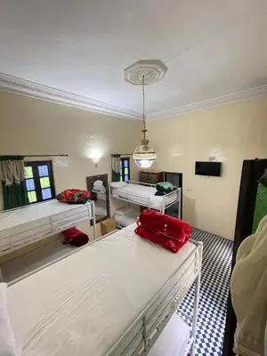 a room with three beds in it with a room with at Dar Atlantic in Fès